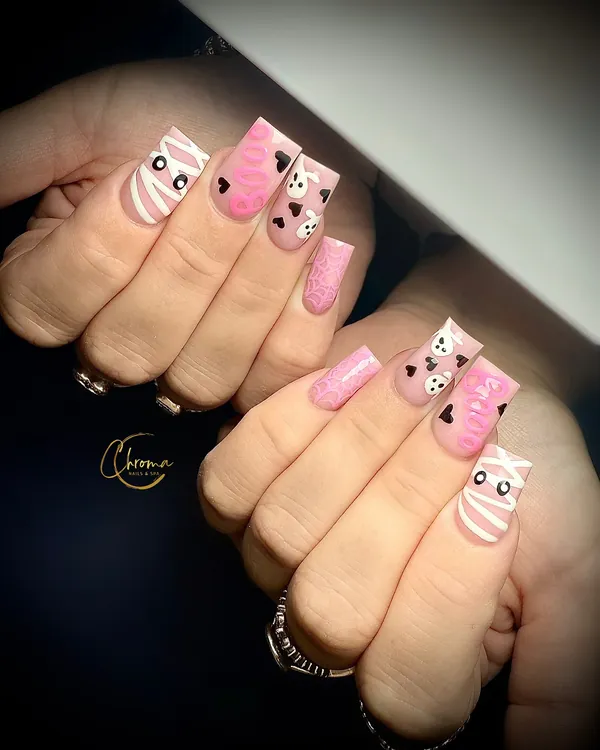 Pink square nails with mummy wraps, little skulls and black hearts
